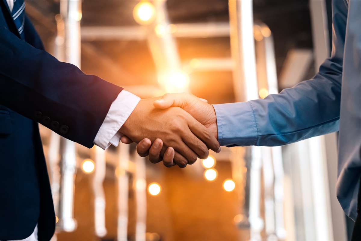 fusione fastweb + vodafone due uomini d'affari si stringono la mano