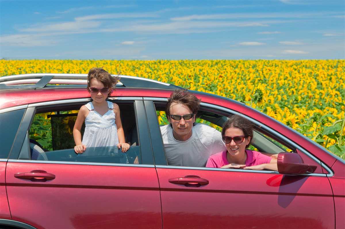 famiglia a bordo di un'auto con prato con girasoli come sfondo