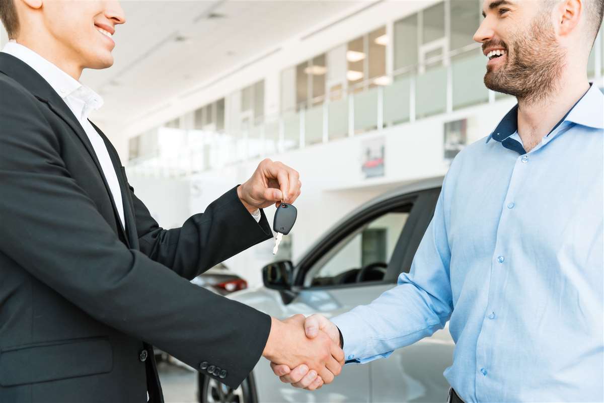 due persone che si stringono la mano dopo acquisto auto