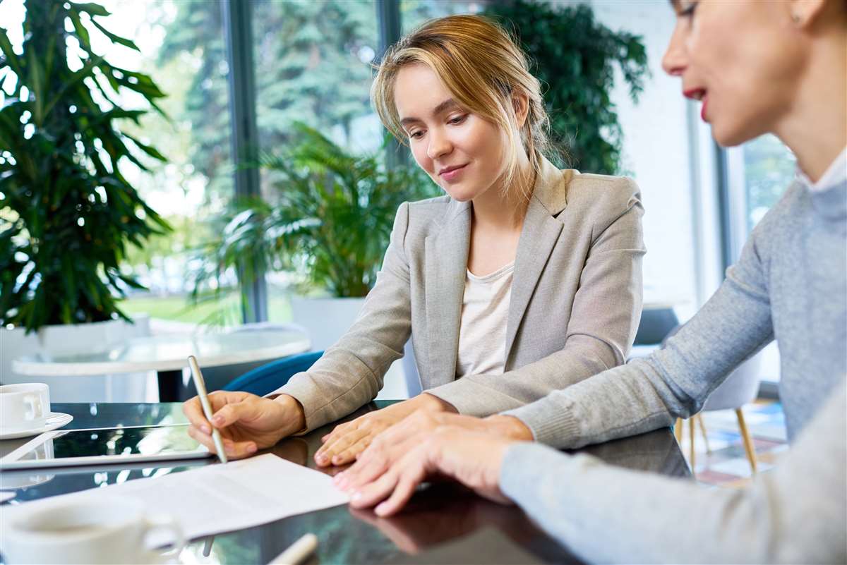 giovane lavoratrice sorridente firma un contratto di lavoro