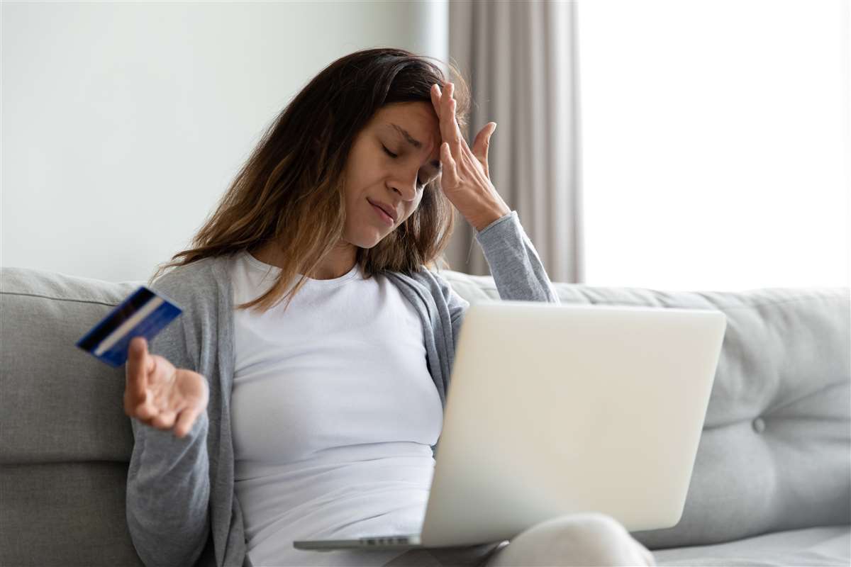 donna al computer con carta di credito che si dispera