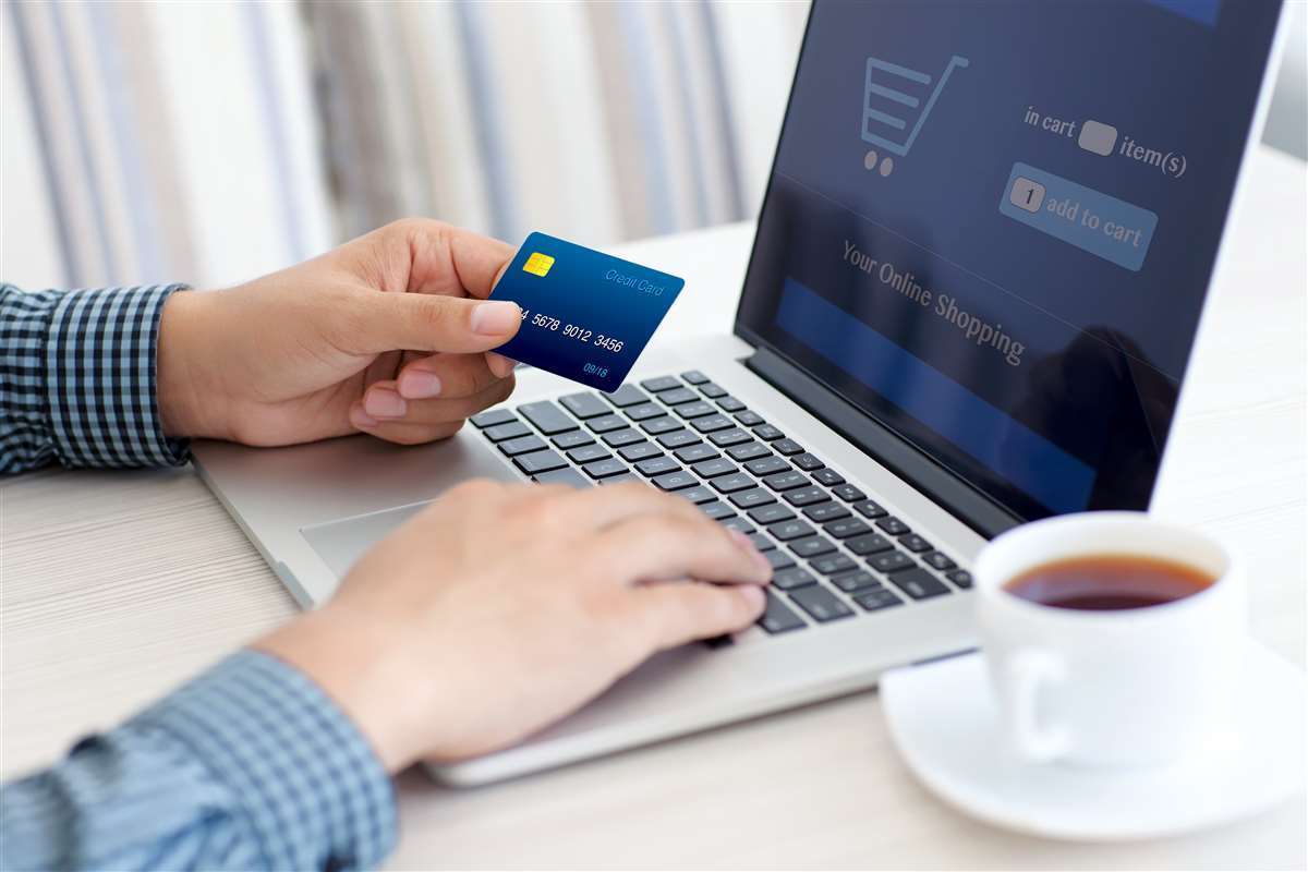 uomo fa shopping online con carta di credito sul computer portatile