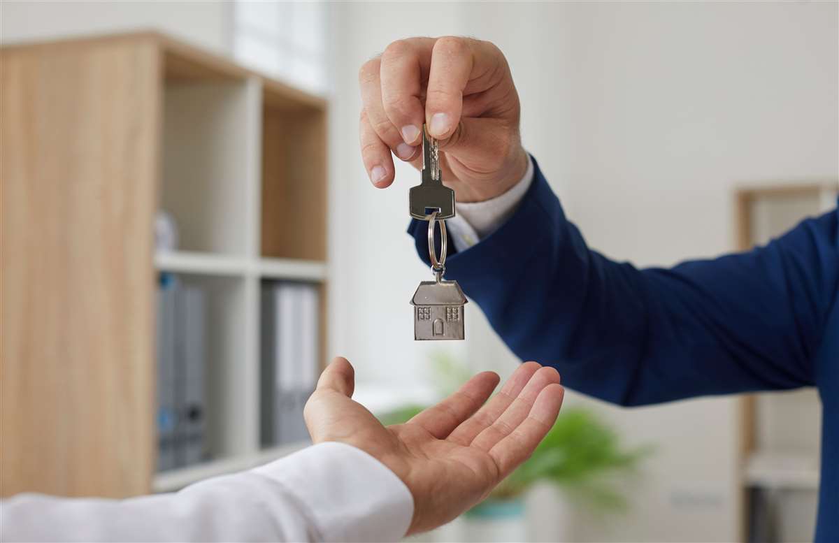 agente immobiliare consegna chiavi al nuovo proprietario di casa