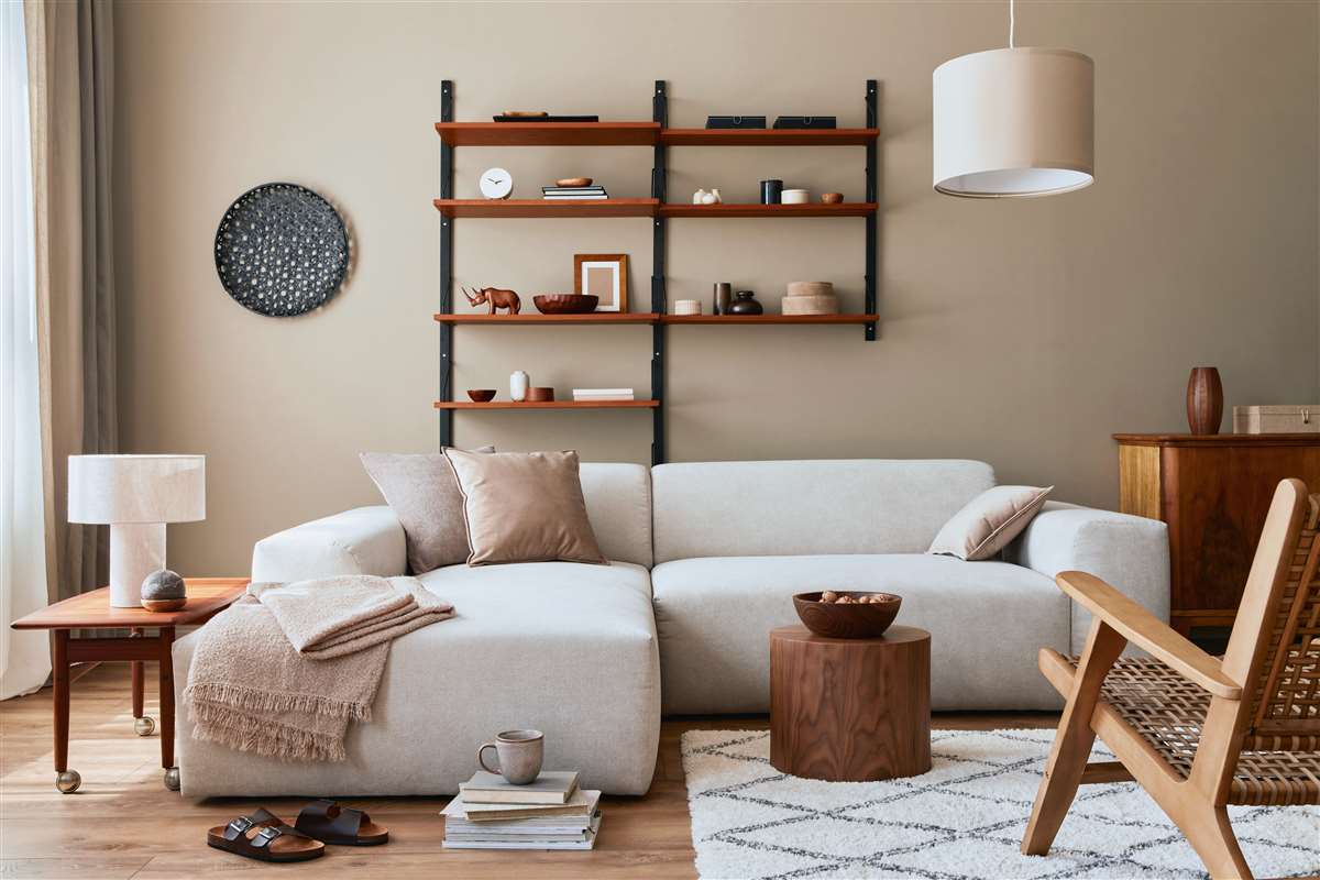 interni moderni di un soggiorno con divano beige, tavolino, lampada e tappeto
