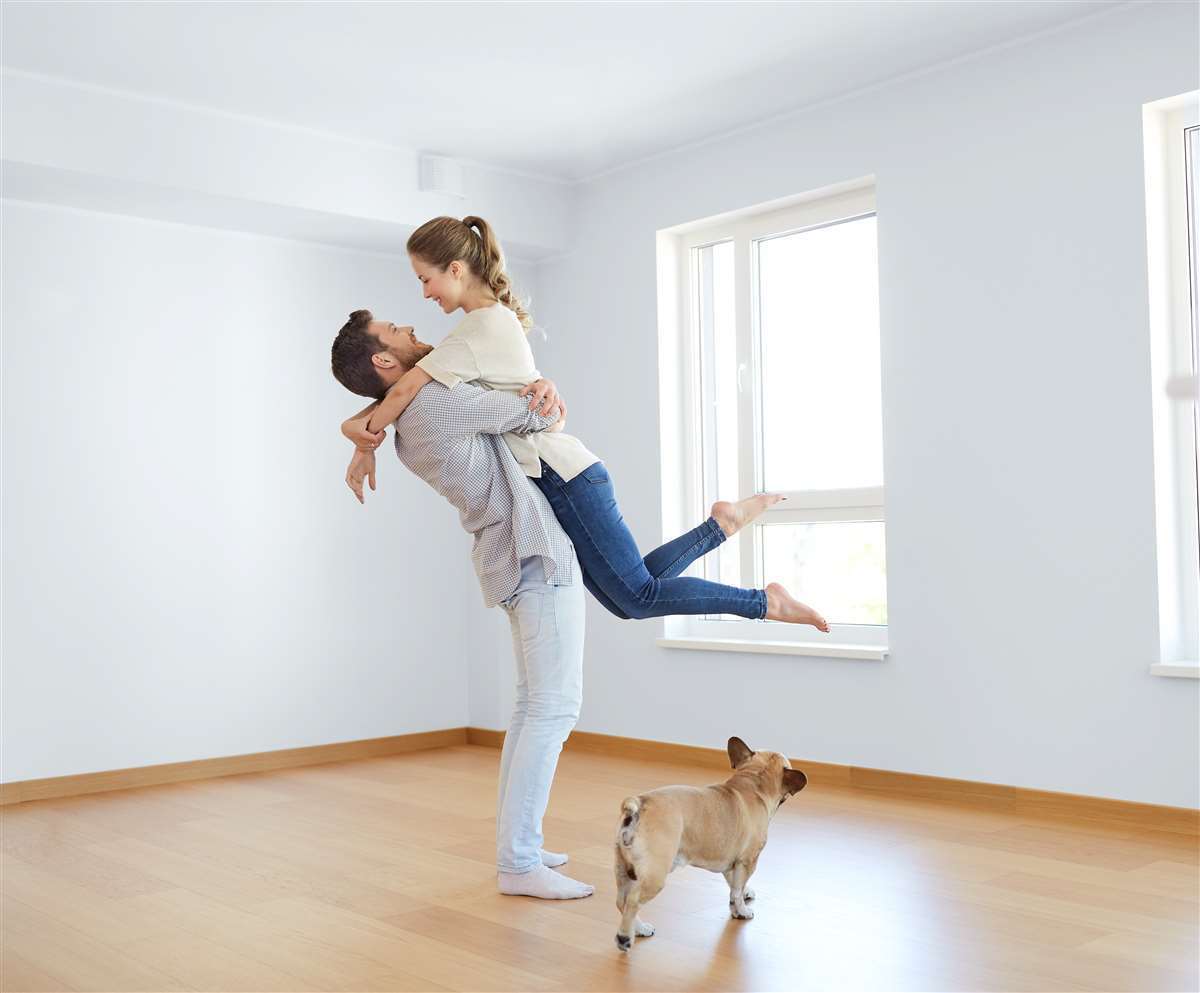 coppia felice con cane nel nuovo appartamento
