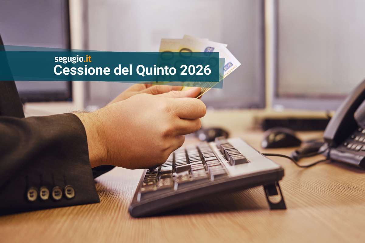 un uomo con banconote in mano davanti al pc