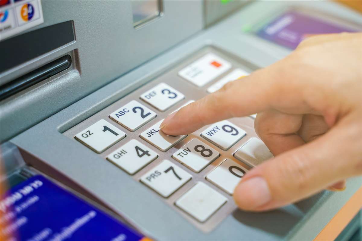 persona digita codice all'ATM