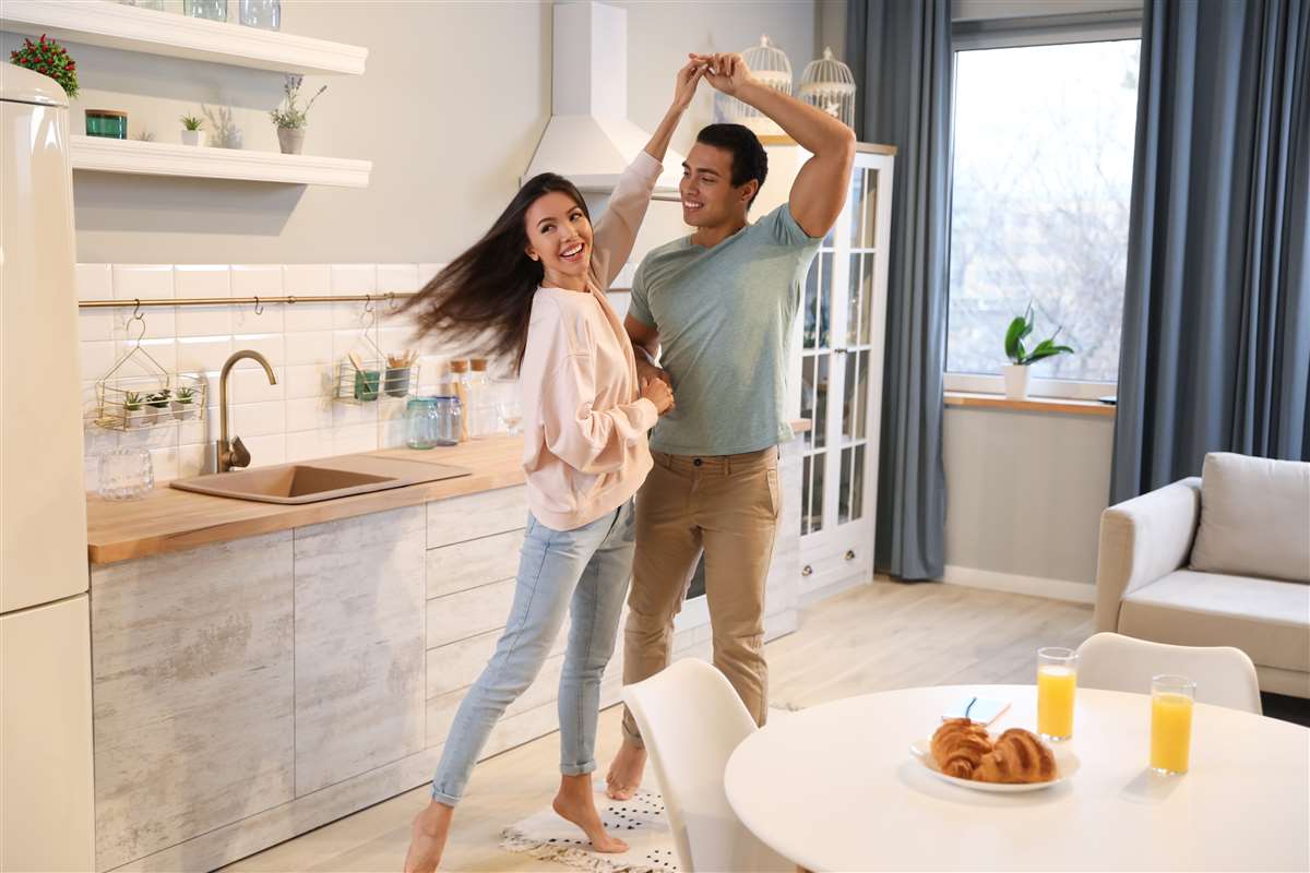 coppia giovane balla nella cucina di casa