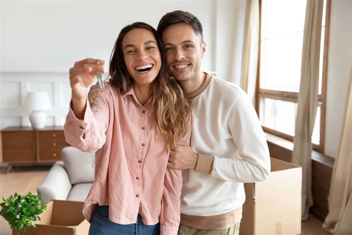 coppia felice mostra chiavi della prima casa
