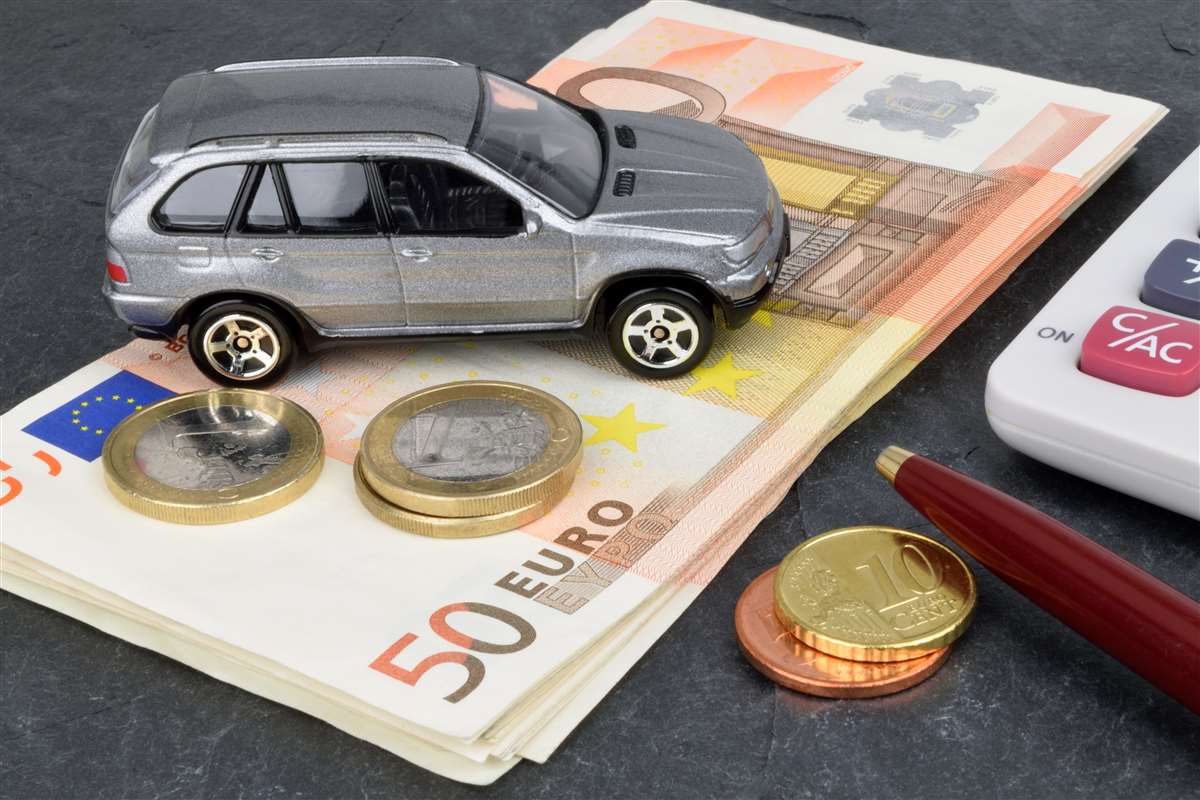 costo auto modellino di auto sopra a banconote e monete, vicino una calcolatrice