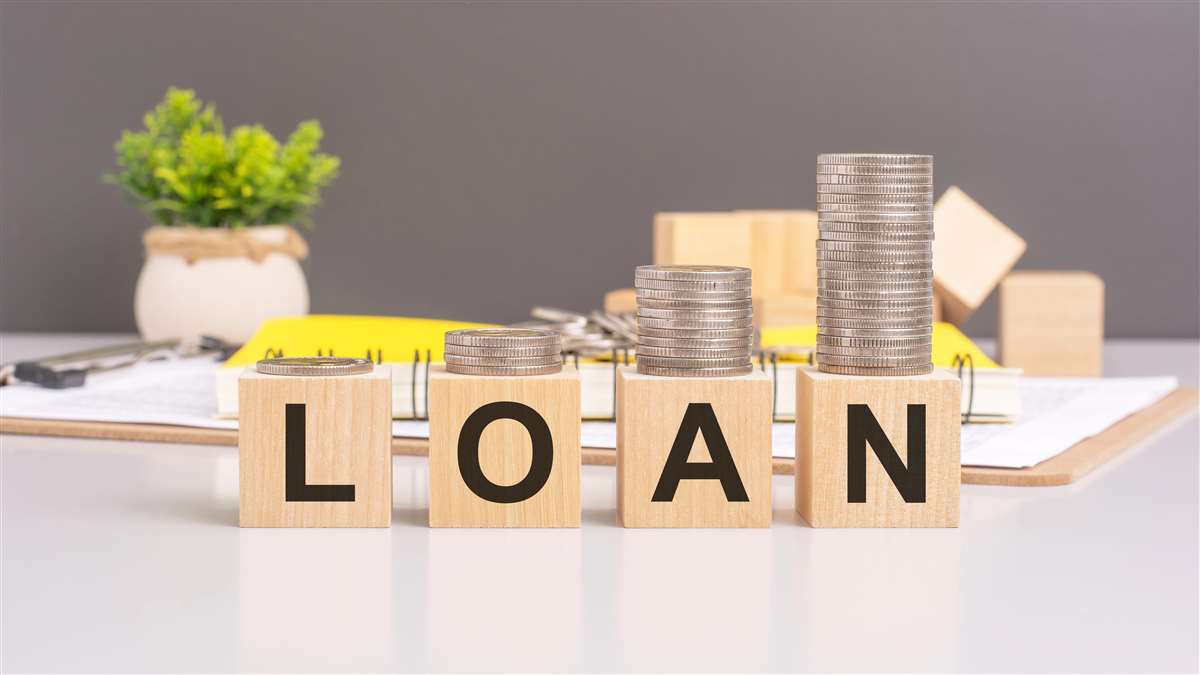 scritta loan su cubetti di legno con sopra pile di monete