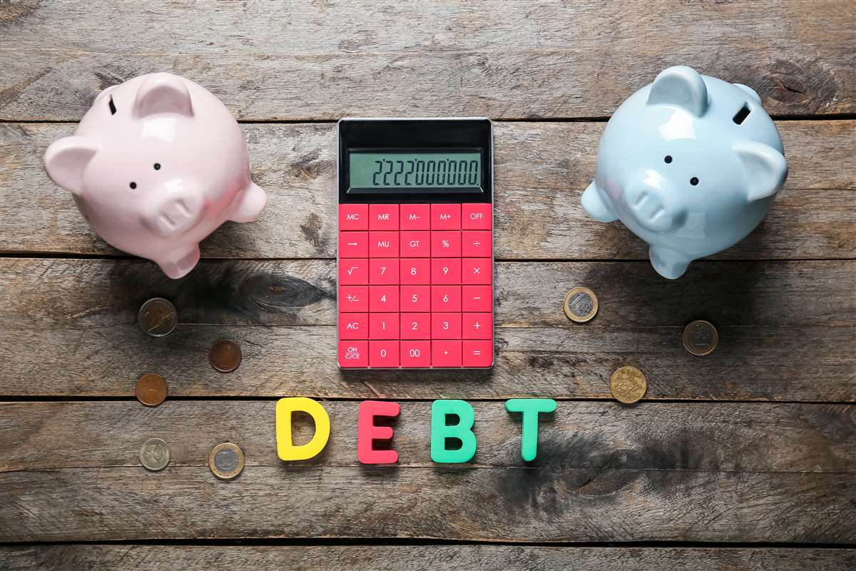definizione di debito residuo scritta debt sotto a calcolatrice e a due salvadanai