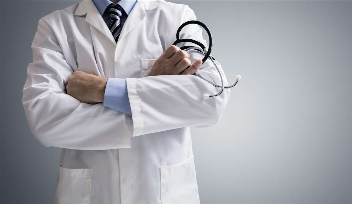 Dottore in camice bianco e stetoscopio in mano