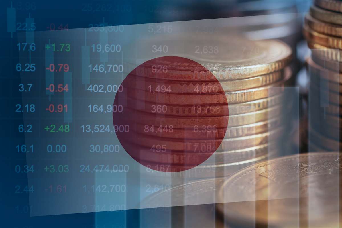 economia giapponese bandiera del giappone su grafico economico, sullo sfondo pile di monete