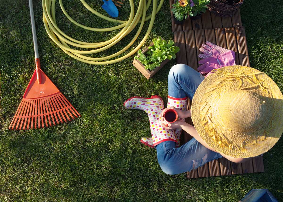 donna con cappello e attrezzi da giardinaggio seduta in campagna