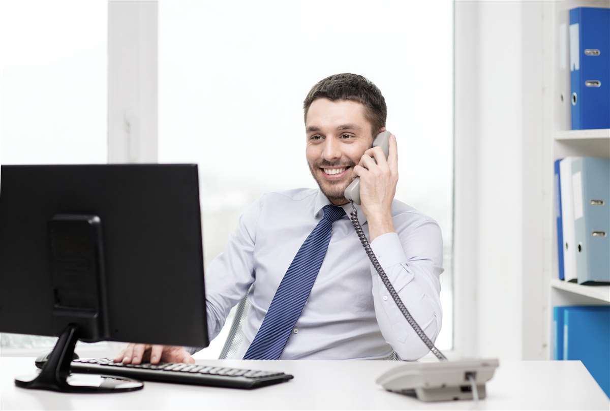 giovane business man al telefono davanti a un monitor