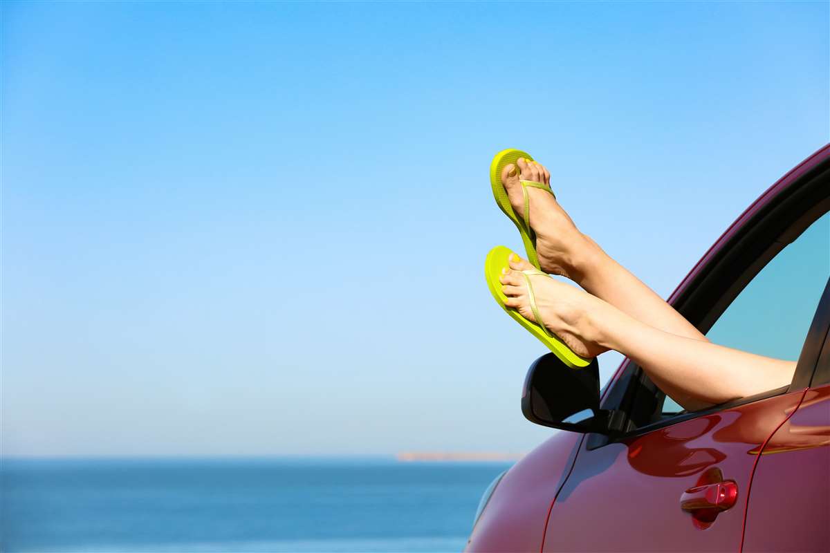guida con infradito infradito sporgono dal finestrino di un auto