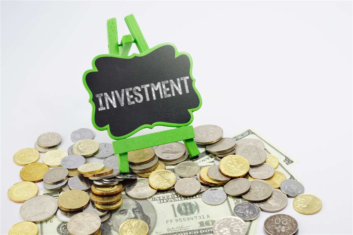investimenti immobiliari scritta investiment su lavagnetta con denaro versato sul pavimento