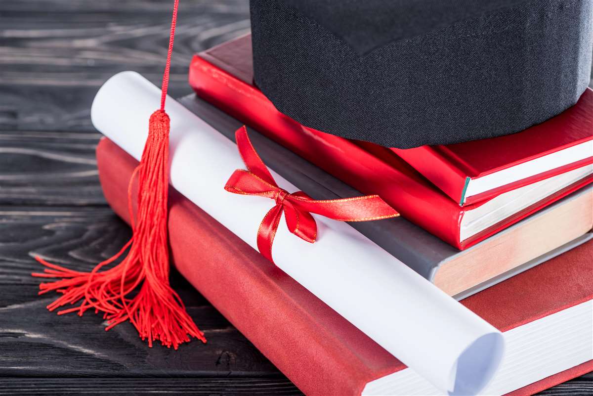cappello da laurea sopra a libri