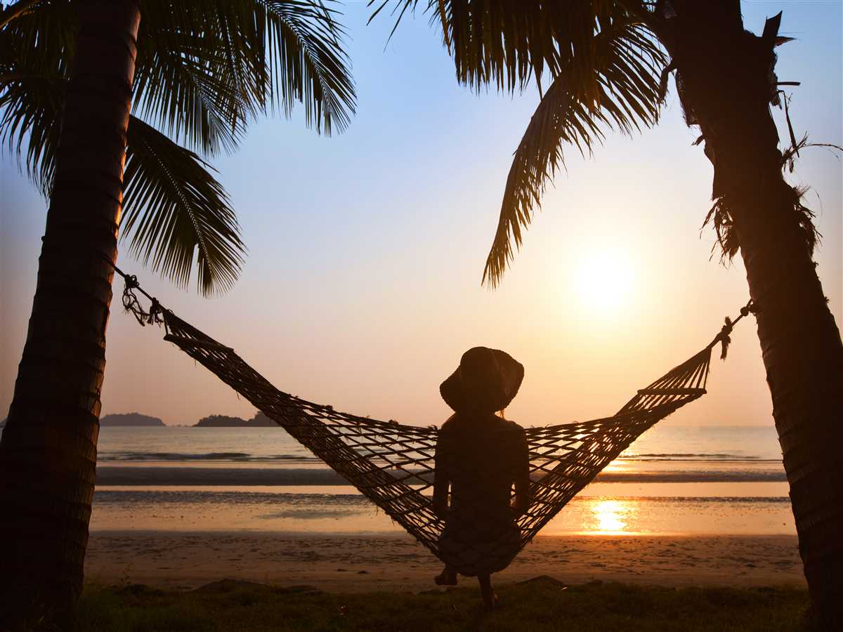 prestiti vacanze ragazza seduta su un'amaca con la luce del tramonto