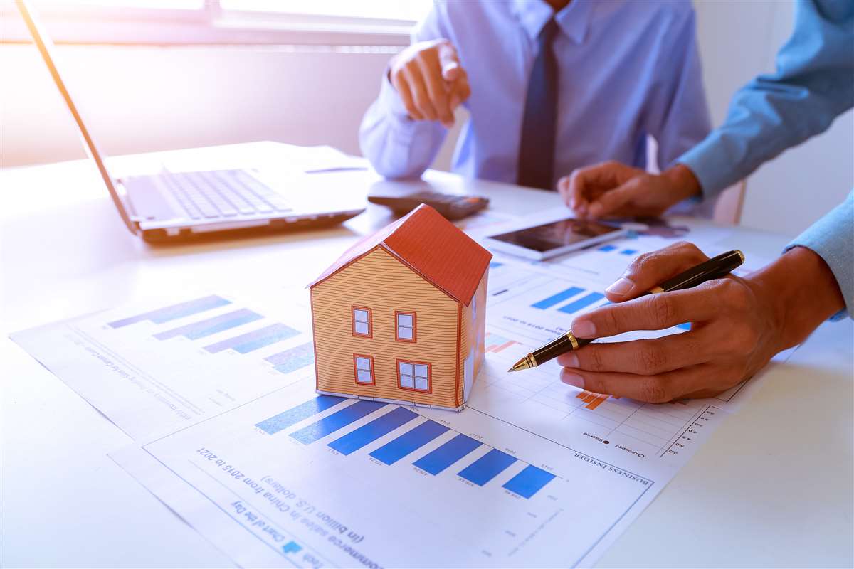 agente immobiliare mostra il progetto della casa ai clienti