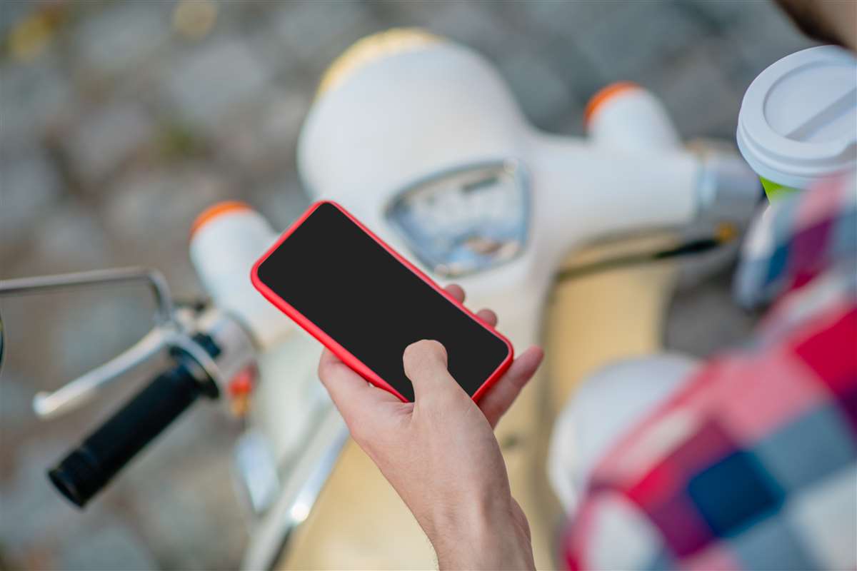 offerte telefonia mobile persona seduta sul motorino che utilizza lo smartphone