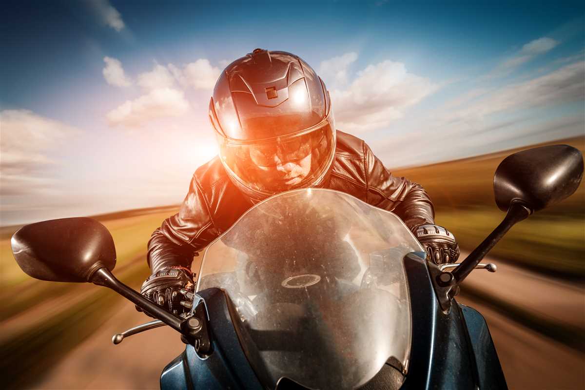 Motociclista con casco in sella a una moto da strada
