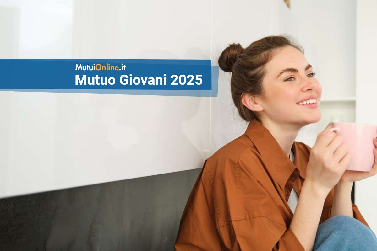 offerte di mutuo giovani 2025 giovane donna sorridente sul divano con tazza tra le mani