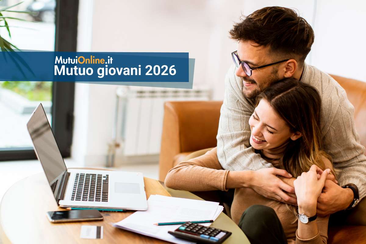 coppia felice davanti al pc, festeggia concessione mutuo