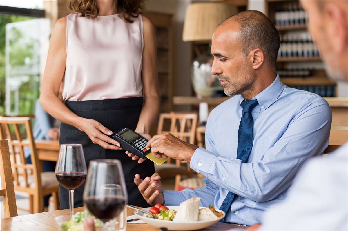 uomo elegante paga pranzo al ristorante con carta di credito
