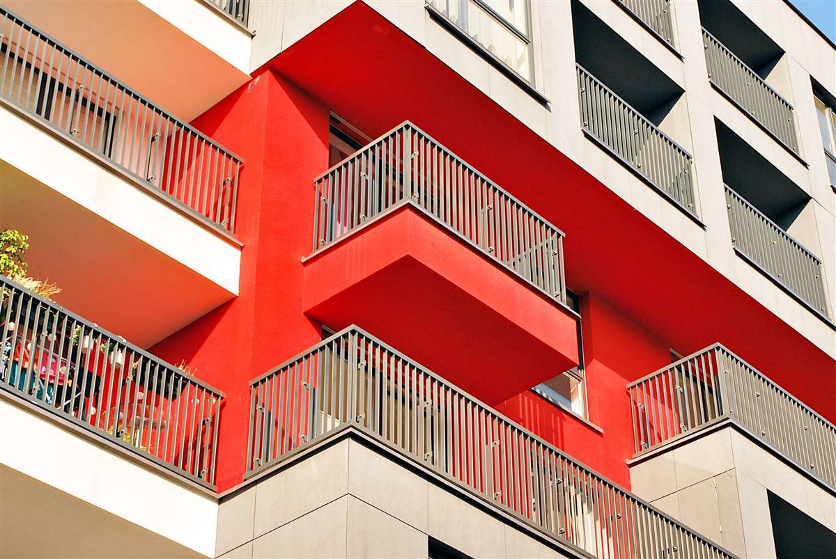 facciata di un palazzo rosso e bianco con dettaglio sui terrazzi