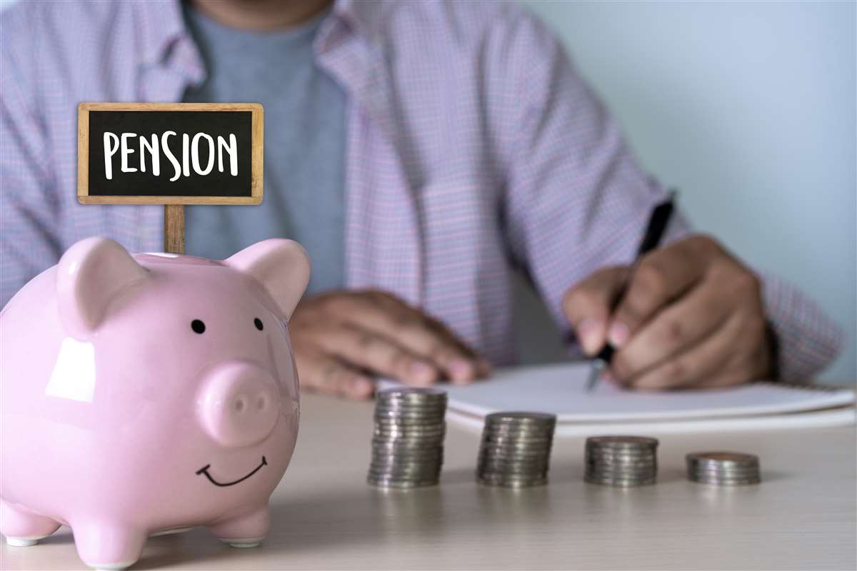 salvadanaio dal quale spunta un cartello con scritto pension, vicino un uomo che fa dei conti