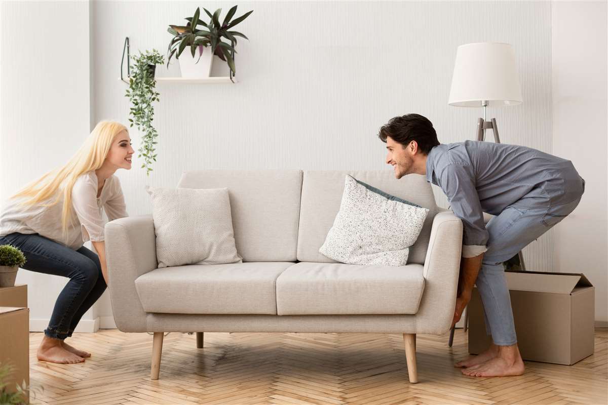 giovane coppia sistema divano nel nuovo appartamento