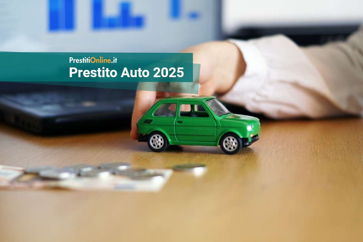 una mano spinge un modellino di auto