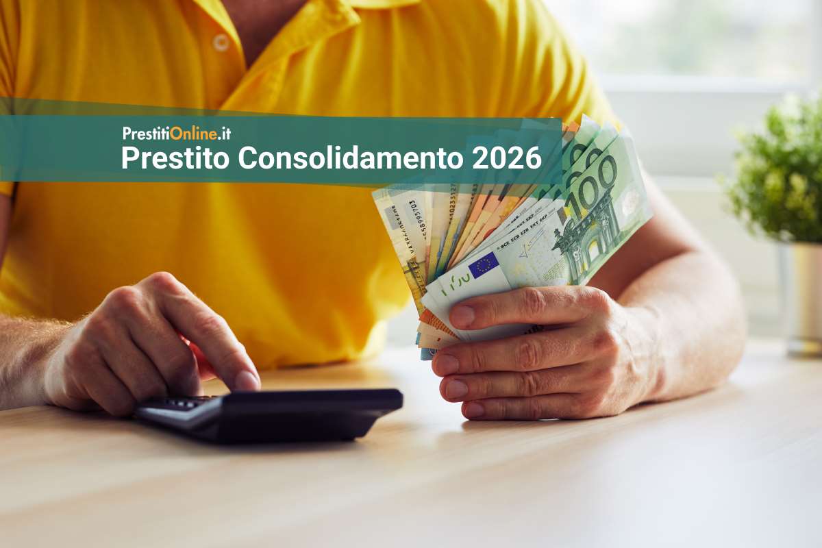 uomo con in mano un ventaglio di banconote fa dei conti con la calcolatrice