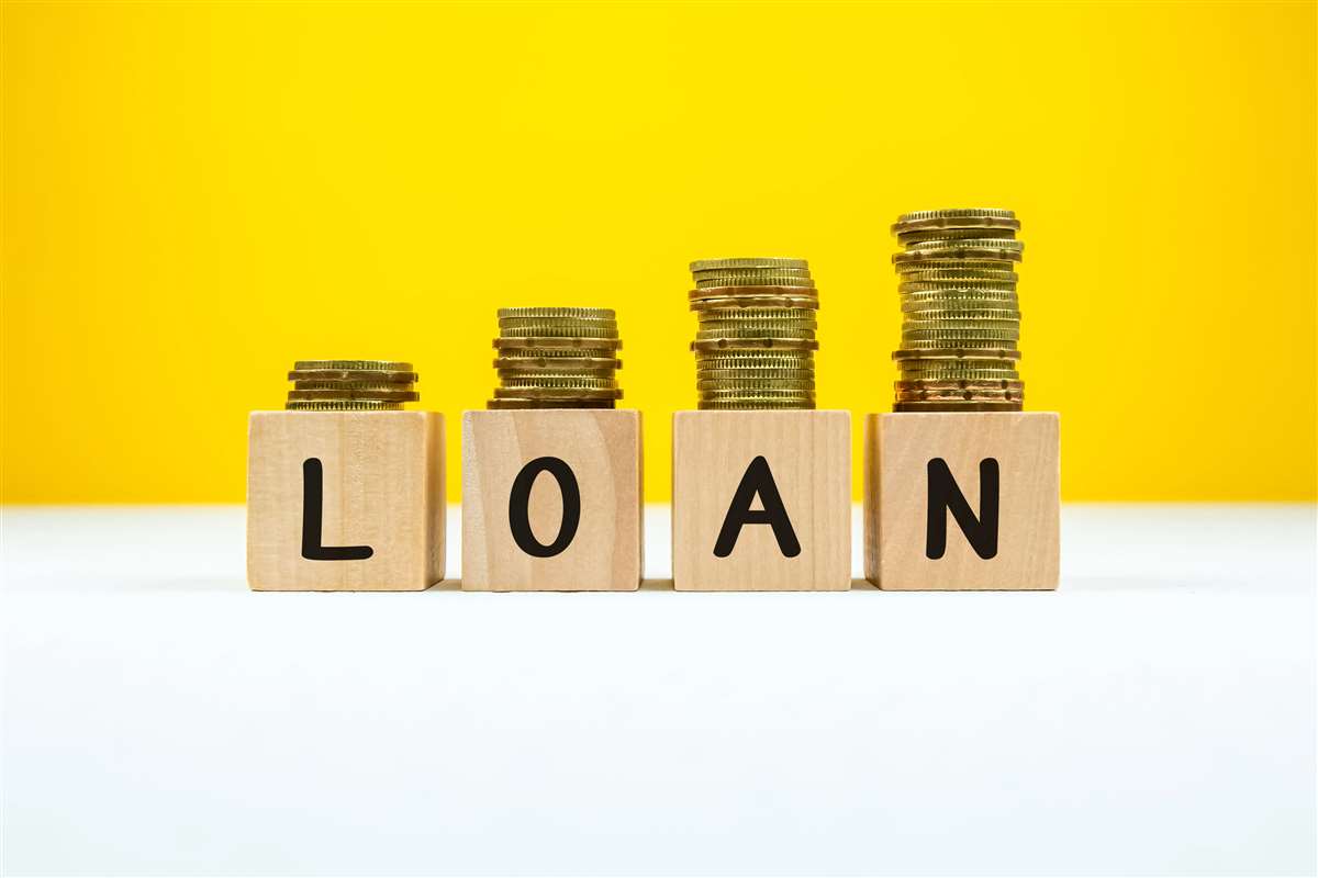 pile di monete su cubetti di legno che mostrano la scritta loan
