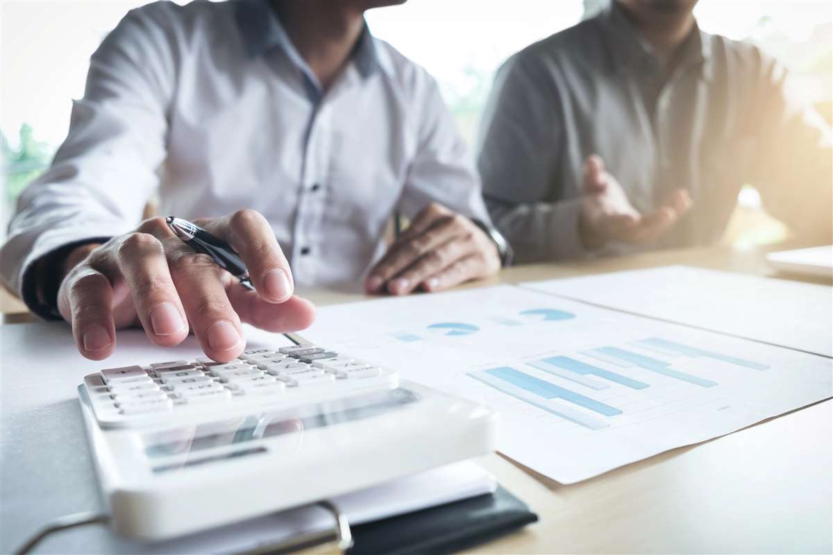 agenti finanziari fanno conti con la calcolatrice