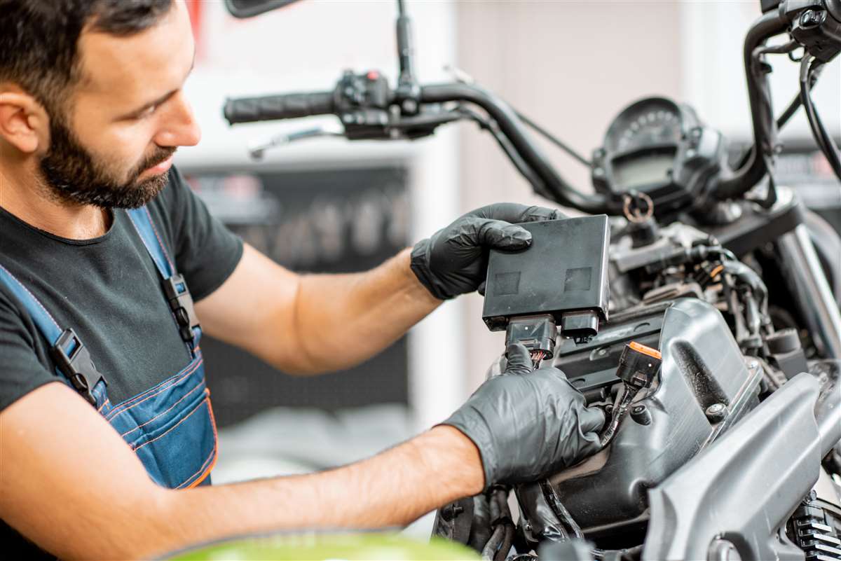 meccanico effettua la revisione di una moto