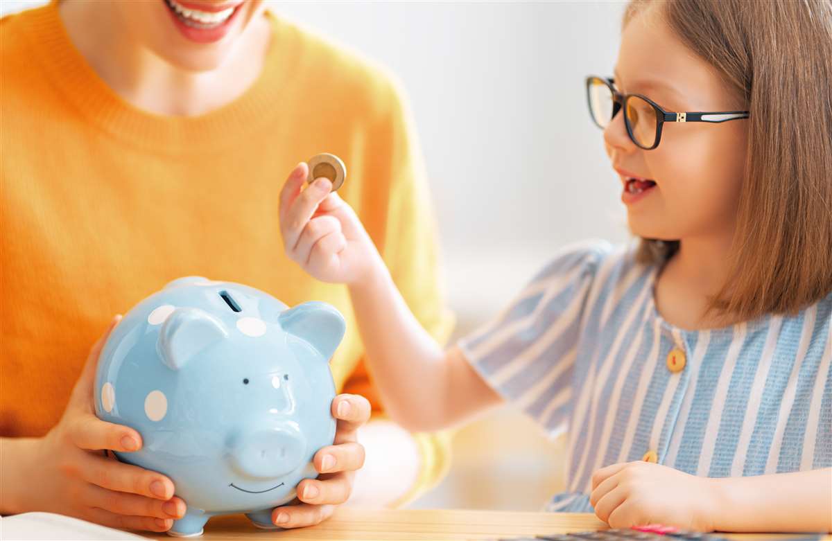 investimenti per giovani una bambina aggiunge una moneta in un salvadanaio