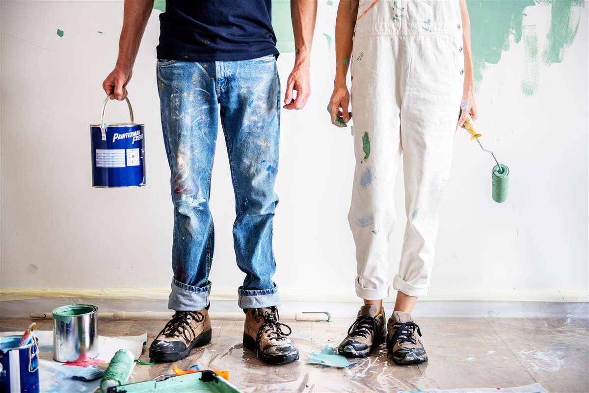 prestito ristrutturazione casa gambe in primo piano di una coppia alle prese con la tinteggiatura di casa