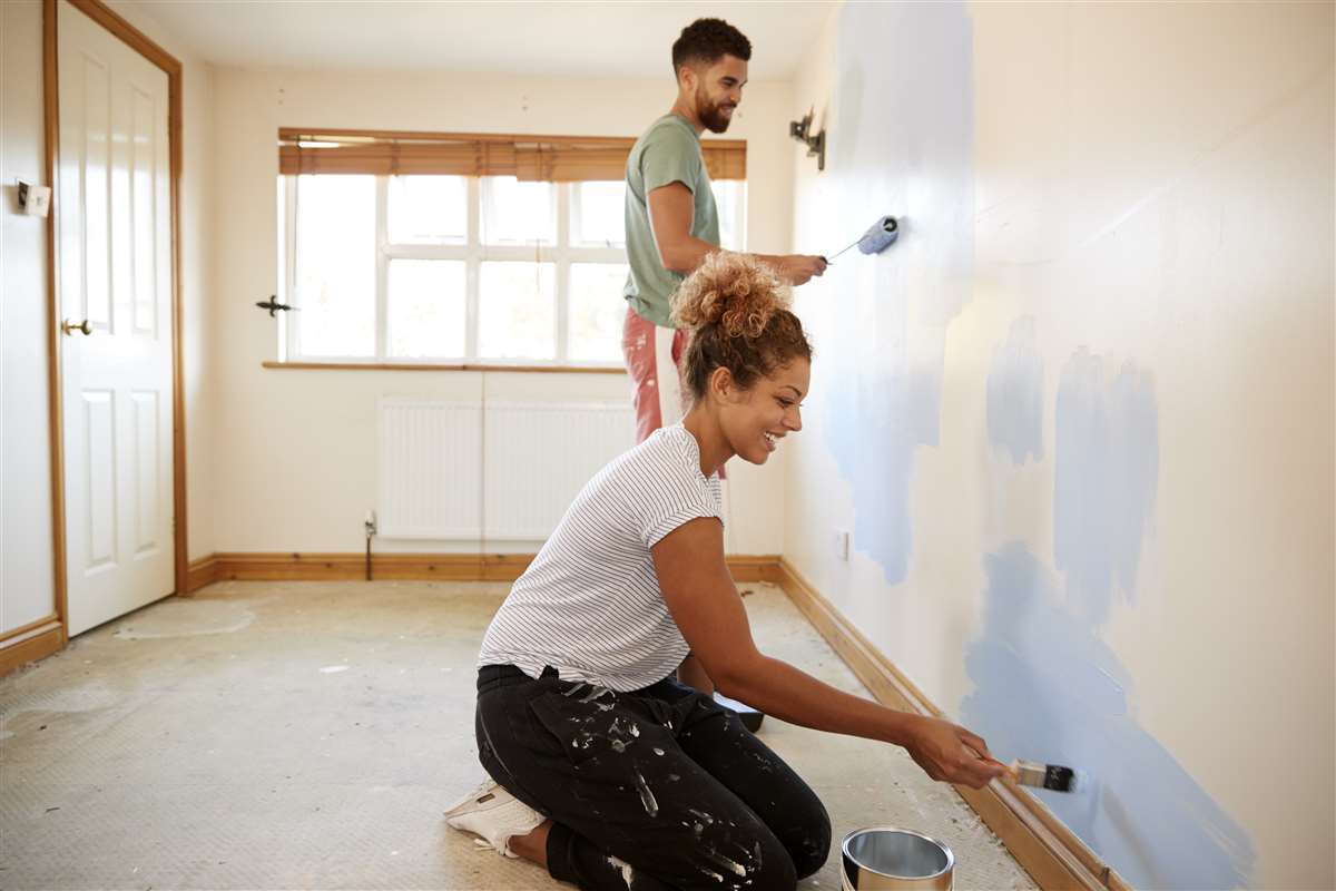 coppia dipinge parete di casa