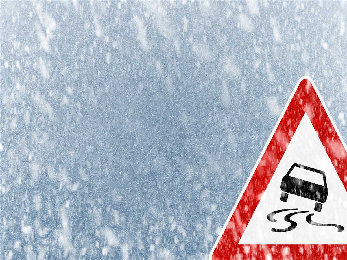 Nevica e un cartello avvisa gli automobilisti che c'Ã¨ un tratto di strada sdrucciolevole