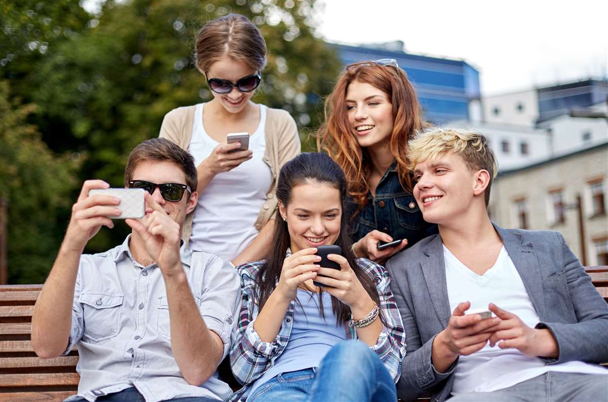gruppo di amici sorridenti con smartphone