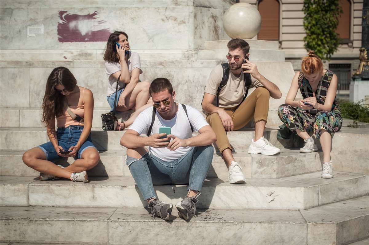 gruppo di amici su gradinata con smartphone