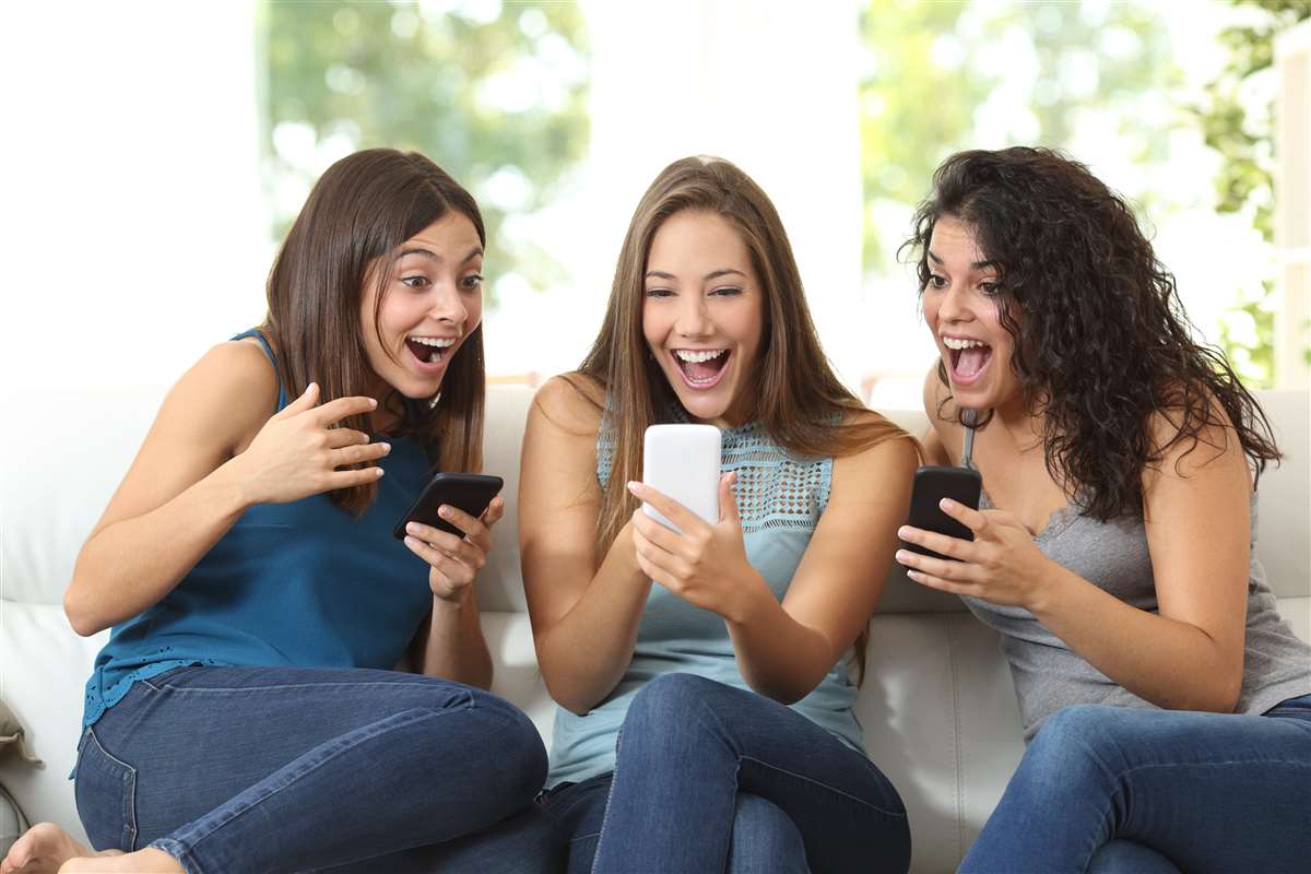 ragazze felici indicano uno smartphone
