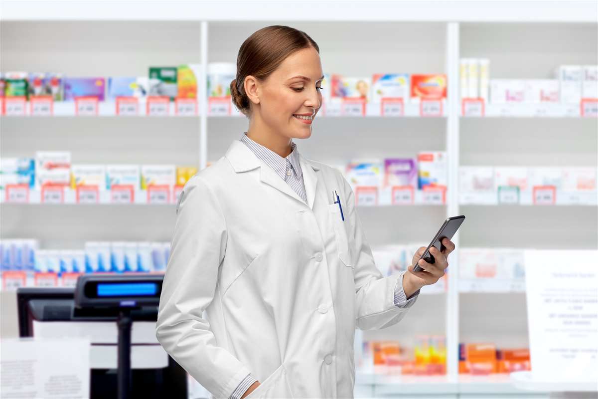 farmacista con smartphone in farmacia