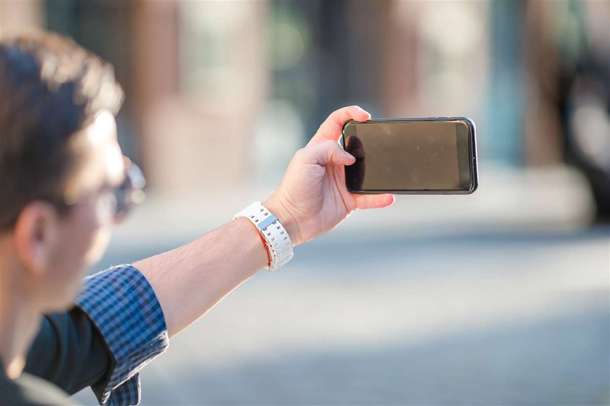 uomo scatta selfie all'aperto con smartphone