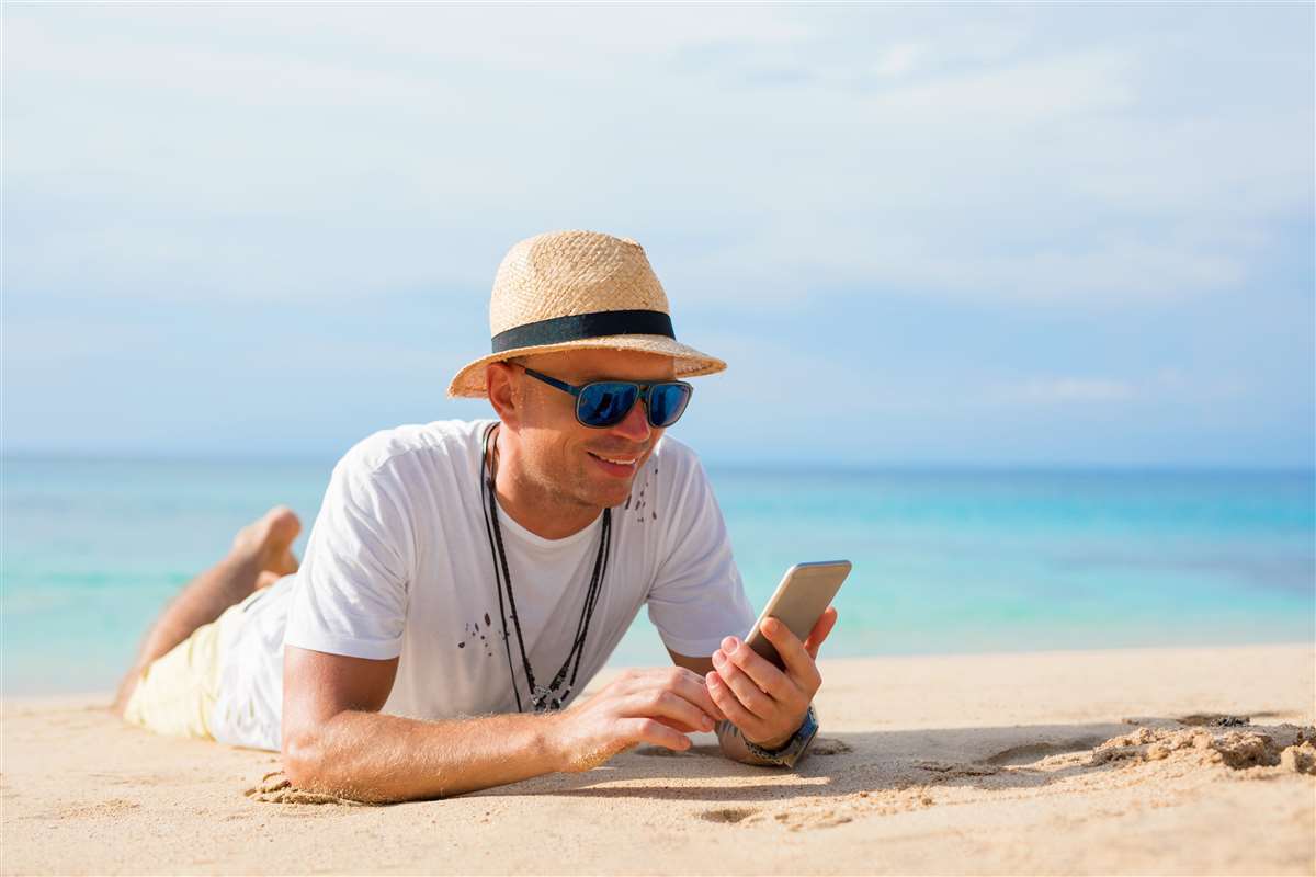 uomo stesso sulla spiaggia con smartphone