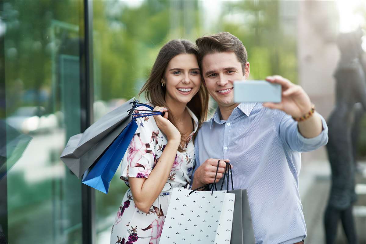 coppia felice in giro per shopping scatta una selfie