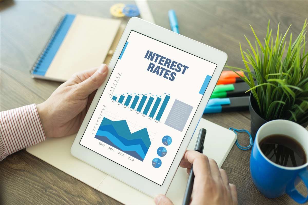 tablet con schermata che mostra grafici e scritta interest rates